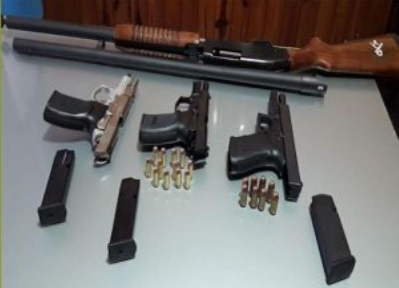 Una escopeta y tres pistolas con sus cargadores y balas.