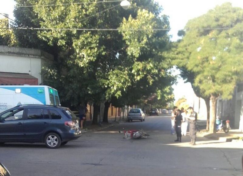 La moto tendida en el pavimento.